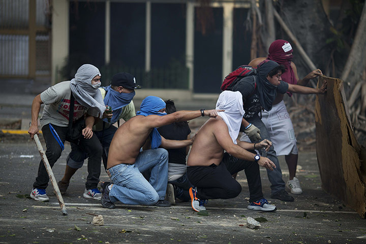 20 Photos: Anti-government protesters take cover in Caracas, Venezuela