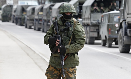 Armed servicemen wait in Russian army vehicles
