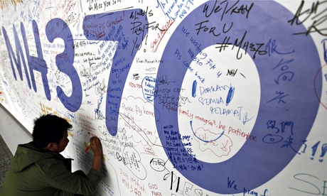 A man writes a message for passengers of Malaysian Airlines flight MH370 at Kuala Lumpur airport