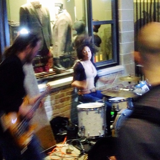 DAMS band playing on a street corner outside an antique store