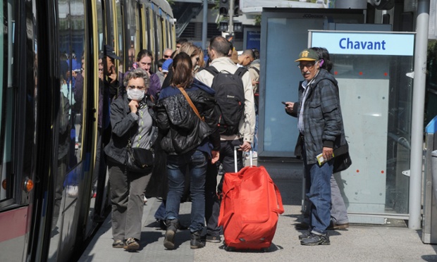 People stand in front of a tramway 2014 in the city of Grenoble