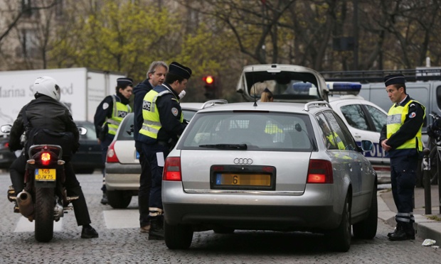 Police officers control cars with number plates ending in even numbers, on March 17, 2014 in Paris, as Paris resorted to drastic measures to curb soaring pollution levels