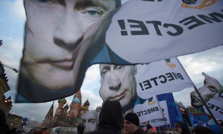 People rally in Red Square with banners and portraits of Vladimir Putin, reading 