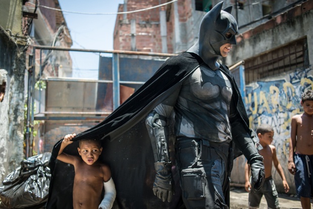 Children play around a man dressed as Batman at the Favela do Metro slum in Rio de Janeiro, Brazil.
