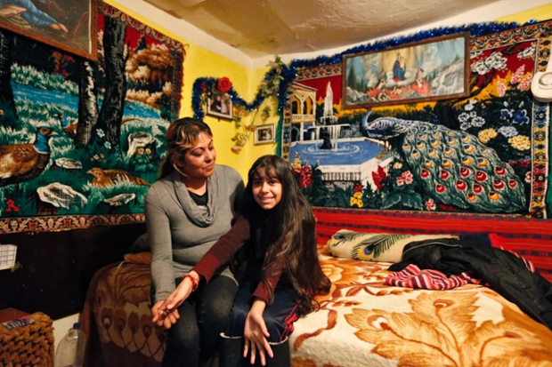 Niculina Fieraru, 39, poses with her daughter Flori Gabriela Dumitrache, 13, in their room in Gura Sutii village, Romania. Niculina Fieraru is unemployed and has two children. She hopes that her daughter will become a seamstress. Flori Gabriela wants to become a pop singer and she hopes to go to high school in a town 14 miles away. Her family cannot afford to pay for it, but a Romanian NGO has offered a scholarship to make this possible.
