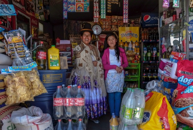 Lucia Mayta, 43, and her daughter Luz Cecilia, 12, pose for a photograph inside their bodega in La Paz, Bolivia. Lucia studied until the fourth grade of primary school, and knows how to read and write and do basic maths. She runs a bodega, and the family live in a back room. She hopes to build a house in the future. Luz Cecilia is in seventh grade and wants to be a singer.