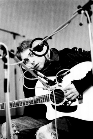 Kurt Cobain, posed, looking to camera, recording in Hilversum Studios, with acoustic guitar.