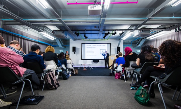 Attendees on chairs watch a presentation on a screen by Shazad Awan, technology director at Condé Nast International