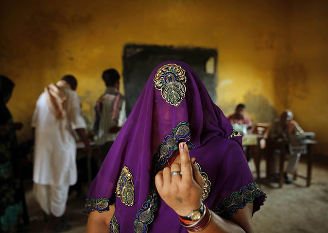 20 Photos: A woman shows the ink mark on her finger after casting her vote in India