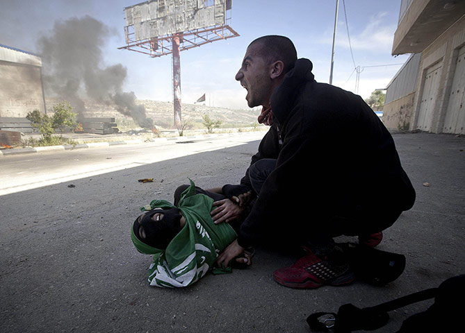 20 Photos: A Palestinian shouts for help after teenager Mohammad Abu Daher was shot