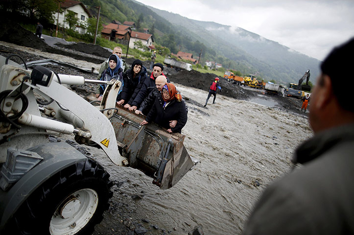 20 Photos: People carried by a front loader from their flooded houses in Topcic Polje