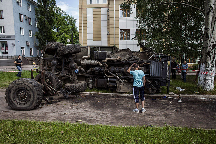 20 photos: A Ukrainian man stands in front of a destroyed truck in Donetsk