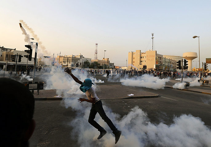 20 photos: An anti-government protester throws back a tear-gas canister in Bahrain