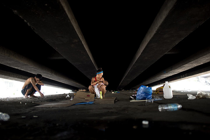 20 photos: A homeless man rests near his wife and daughter under a flyover in Manila