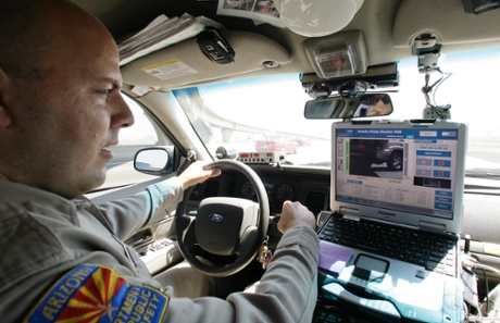 Arizona Department of Public Safety officer David Callister keeps an eye on his dashboard computer as it reads passing car license plates.