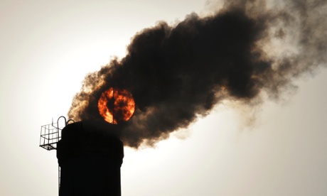 The sun is seen behind smoke billowing from a chimney of a heating plant in Taiyuan, Shanxi province