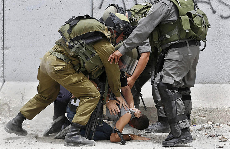 20 Photos: A Palestinian is detained during a protest near Ramallah