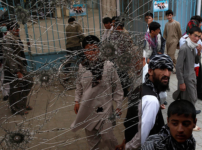 20 Photos: People look at a window of a bus damaged by bomb blasts in Kabul