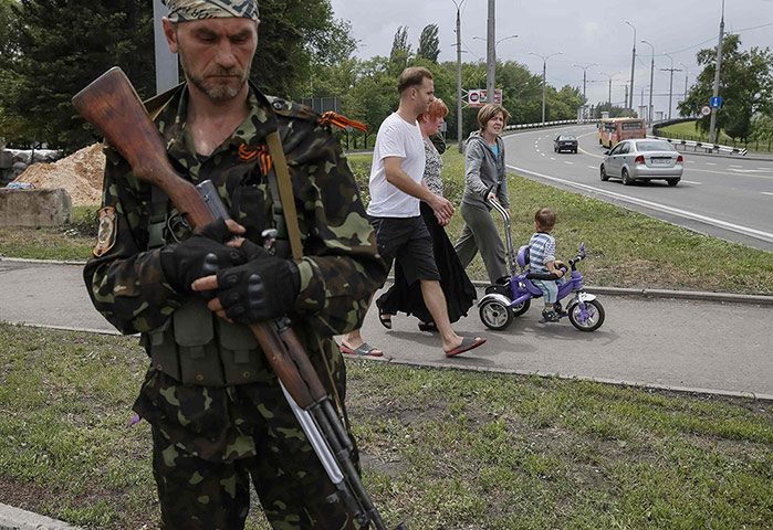 20 Photos: A pro-Russian rebel from the Vostok Battalion stands guard in Donetsk