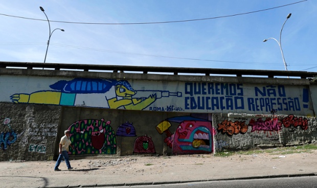 Graffiti depicting the 2014 World Cup mascot Fuleco the Armadillo pointing a rifle at a message that reads 'We Want Education' and 'Not Repression'.