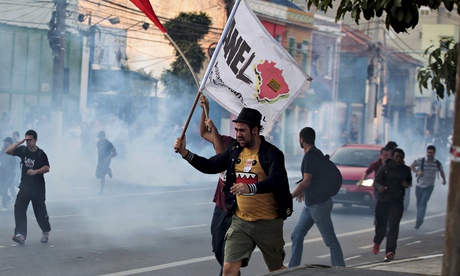 Demonstrators run from tear gas fired by police outside Ana Rosa subway station in Sao Paulo