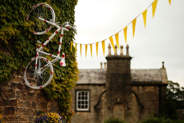 A bicycle decorated with polka dots hangs from the wall of a pub on the route of the Tour de France in Addingham