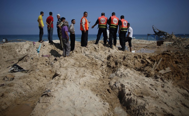 Rescuers inspect the remains of a beach cafe hit by an Israeli air strike while people were watching the World Cup semi-final football match, in the southern Gaza Strip city of Khan Yunis. Eight people were killed and at least 15 wounded in the strike.