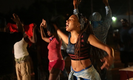 Ferguson protesters defy curfew to confront riot police