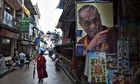 A Buddhist monk walks past a stall selling portraits of the Dalai Lama in Dharmsala, India