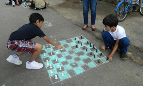 Children playing chess on a chalk chessboard on the street in Bangalore