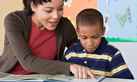 Teacher and pupil reading book