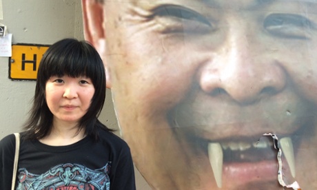 Timmie Yu posed next to a picture of fake-fanged chief executive CY Leung.