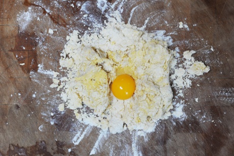 a raw egg nestled within a pile of flour