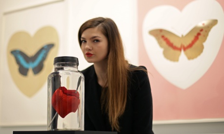 Gallery assistant Rachel Hunt with the piece Love Struck – a resin cast of a pig's heart with a steel crossbow bolt through it.