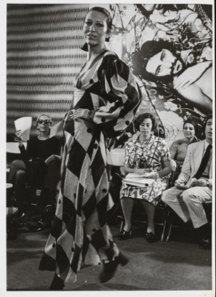 Elsa Peretti modelling a harlequin print silk dress at the opening of the New York shop, July 1971.