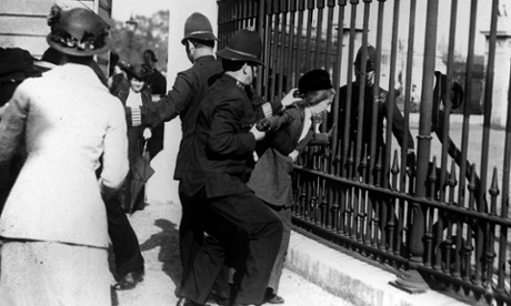 A policeman restrains a demonstrator as suffragettes gathered outside Buckingham Palace in 1914.