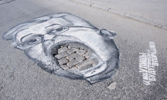 Russian politicians mocked with guerrilla pothole portraits