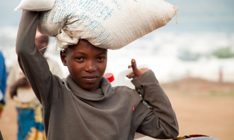 A young refugee carries part of the monthly food ration that the World Food Programme distributes to all inhabitants of the Mahama refugee camp in south-east Rwanda