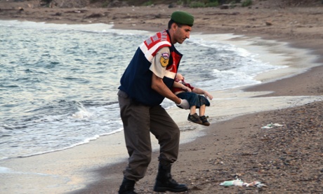 A paramilitary police officer carries the lifeless body of Alan Kurdi, three, after a number of migrants died and a smaller number were reported missing after boats carrying them to the Greek island of Kos capsized.