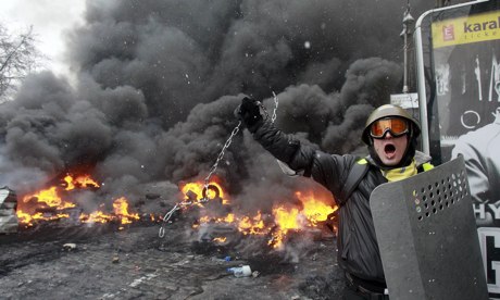 Um manifestante pró-europeu oscila uma corrente de metal durante os distúrbios em Kiev