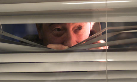 [Image: A-man-peering-through-a-s-002.jpg]