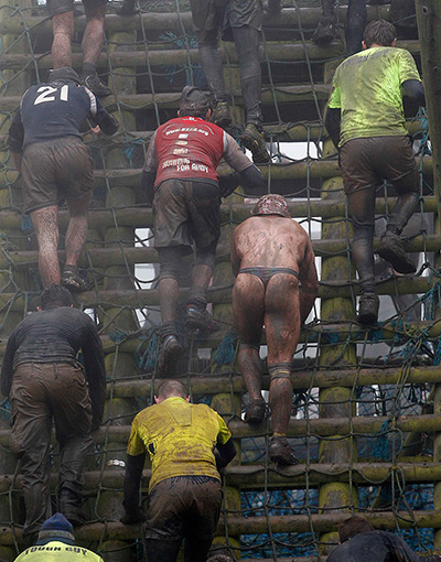 Tough Guy: Competitors climb a cargo net during the Tough Guy Challenge 2012