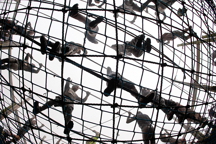 Tough Guy: Competitors cross the cargo net at the Tough Guy challenge 2012