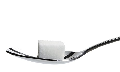 one lump sugar on a spoon isolated on white background
