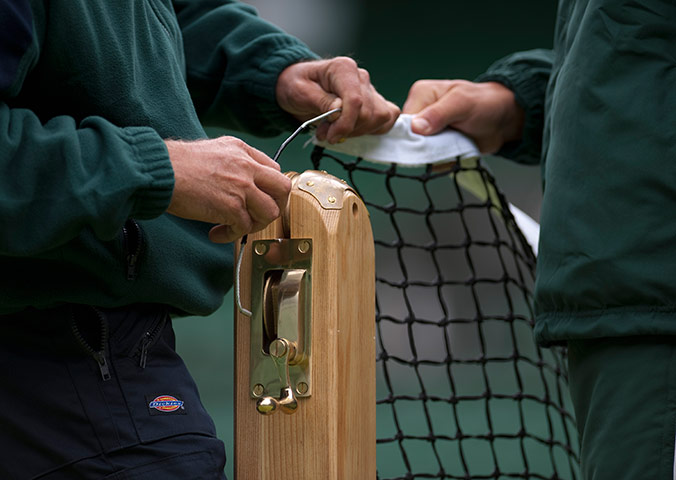 Wimbledon photo book: Staff sets up the net on Centre Court before the start of the Championships