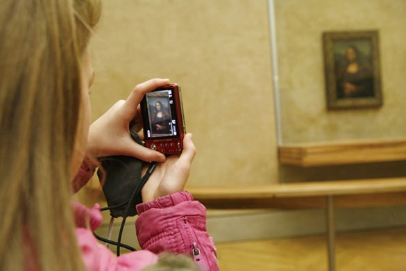 Earthbound images: Tourists photographing the Monna Lisa, Musee Louve, Paris