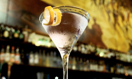 A gin martini with a lemon twist on a bar