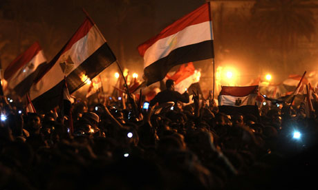 Egyptian anti-government protesters wave flags as they celebrate in Tahrir Square