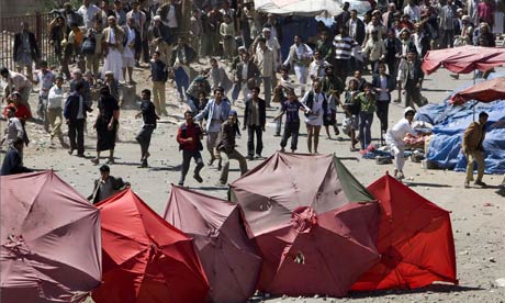 Pro-government supporters throw stones at anti-government demonstrators in Yemen