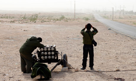 A Libyan rebel aims a rocket launcher in Brega